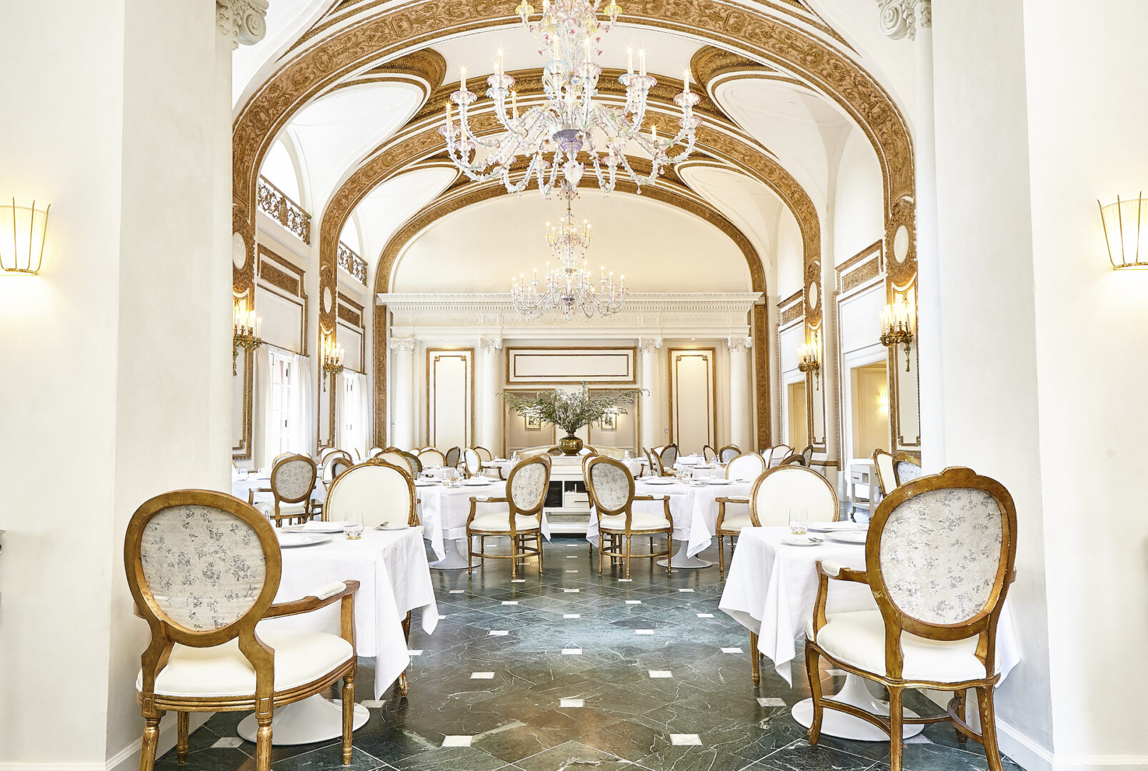 the french room dining room and large chandeliers hanging from arched ceilings