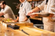 Three chefs making sushi at a sushi bar