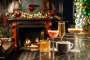 beverages on a table with a christmas decorated fireplace in the background