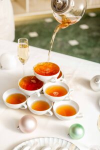 Hot tea being poured into a tower of tea cups
